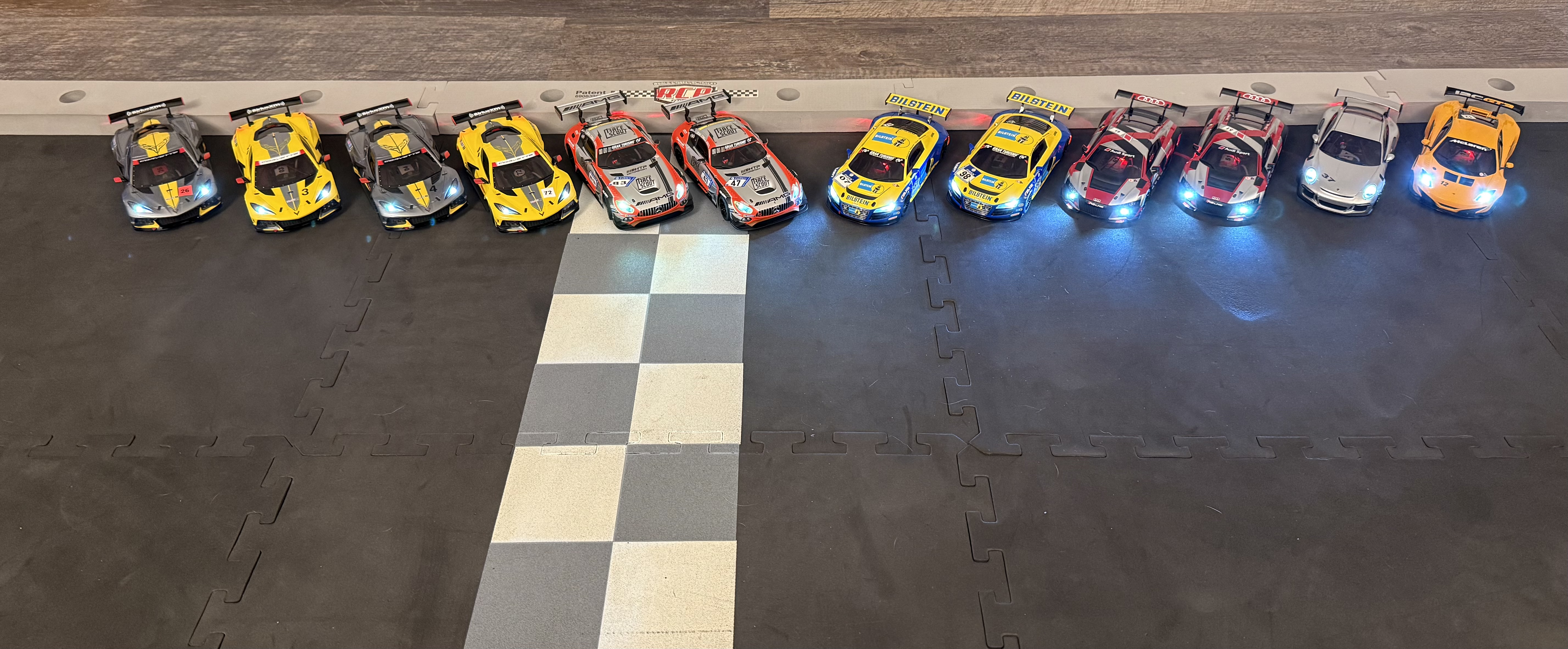 Full fleet of 12 Kyosho Mini-Z RC cars lined up on the minilaps race track